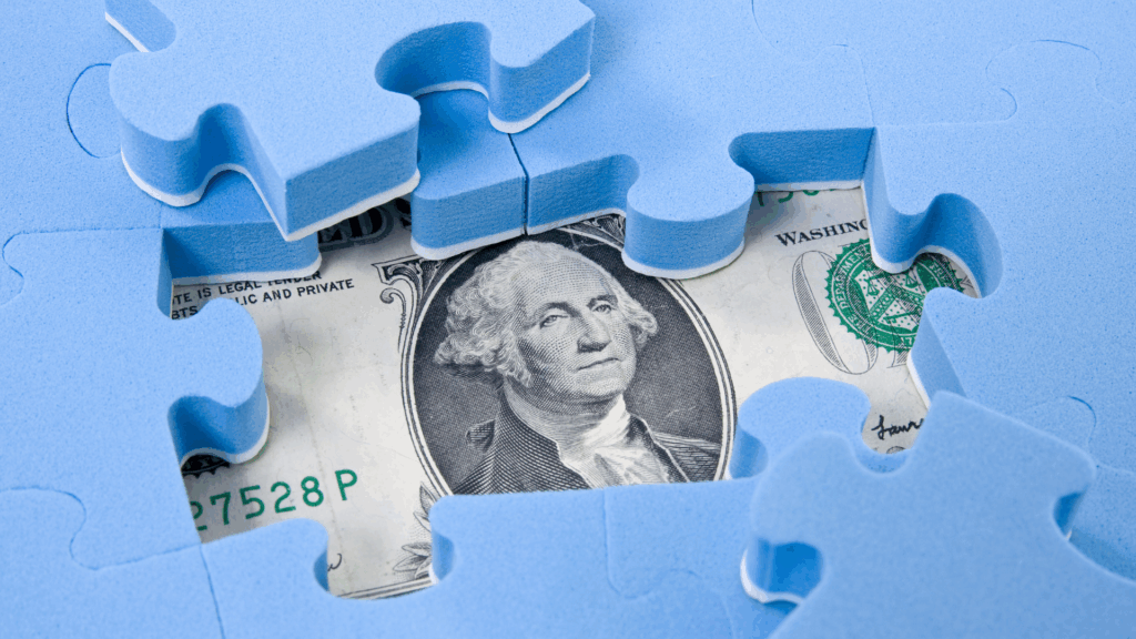 Business financial puzzle with blue pieces and US dollar.